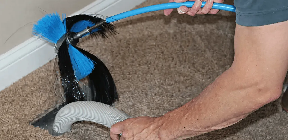 Dryer vent cleaning technician brushing lint from a vent line in Memphis, TN