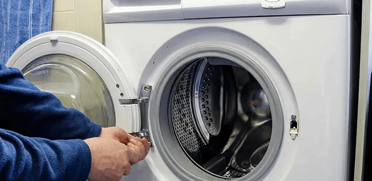 Washing machine repair handyman checking a front-load washer door and latch in Memphis, TN
